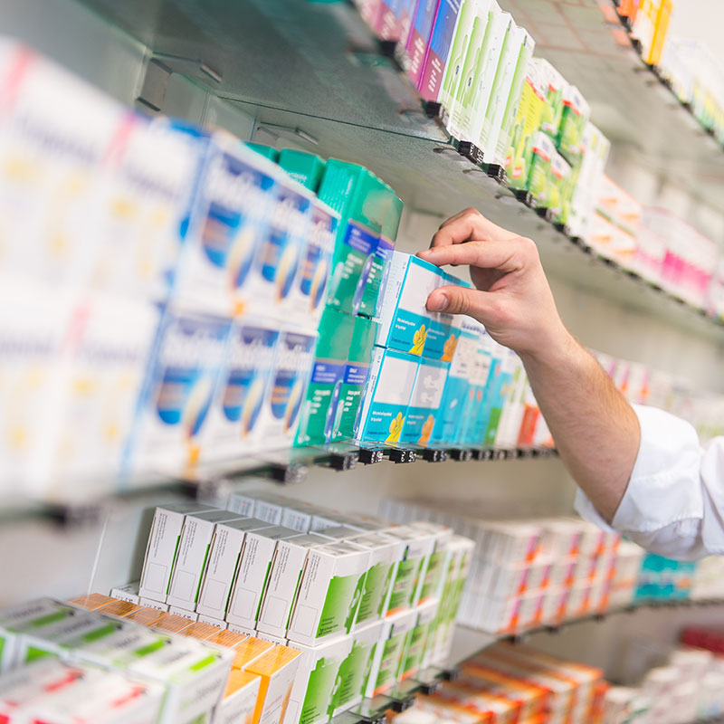 Arzneimittel im Apothekenregal bei der Auswahl einer Medikamentenpackung